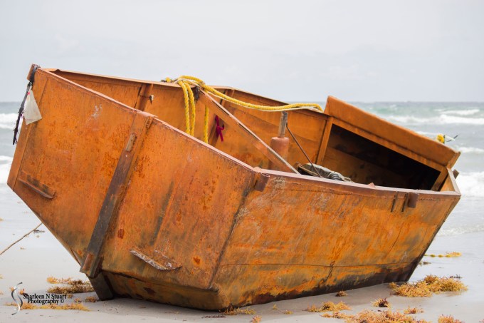 A lonely boat on a stretch of beach at the end of a long and ardous journey.