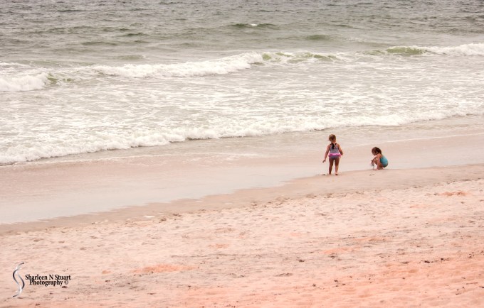 Two little girls playing on the beach